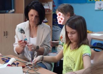 Powiększ zdjęcie: Pani z dziećmi tworzy kukiełki