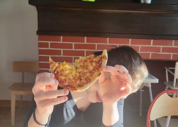 Powiększ zdjęcie: dziewczyna jedząca pizzę