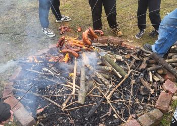 Powiększ zdjęcie: pieczenie kiełbas nad ogniskiem