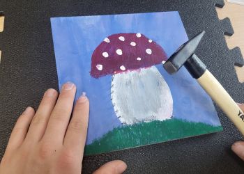 Powiększ zdjęcie: namalowany grzybek, ręka i młotek