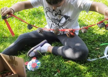 Powiększ zdjęcie: dziecko siedzące na trawie