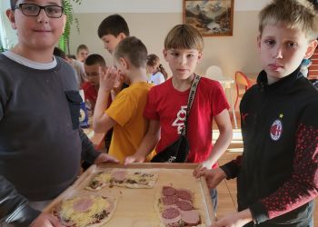 Powiększ zdjęcie: chłopcy niosący pizzę