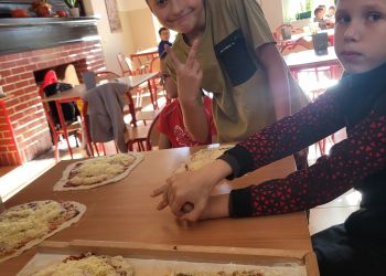 Powiększ zdjęcie: chłopcy przy robieniu pizzy