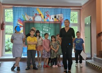 Powiększ zdjęcie: dzieci z nauczycielem na scenie