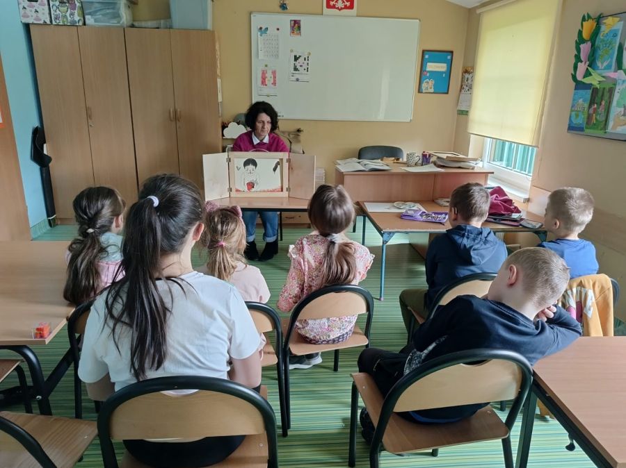 Nauczycielka czytająca dzieciom bajkę podczas teatrzyku